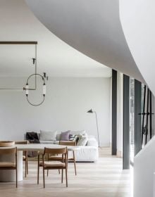 Interior living area with cream linen covered sofas, brown leather chairs, white walls, with ceiling beams, on cover of 'Designer's Next' by Beta-Plus.