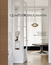Book cover of Quartier Brugmann, L'Art de Vivre in Brussels' Most Stylish Area, with a white interior living room with wood floor, coffee-table, and low hanging light. Published by Beta-Plus.