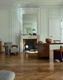 Book cover of Quartier Brugmann, L'Art de Vivre in Brussels' Most Stylish Area, with a white interior living room with wood floor, coffee-table, and low hanging light. Published by Beta-Plus.
