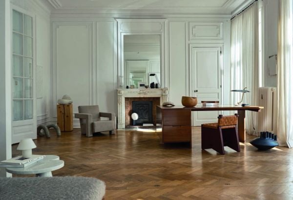Book cover of Quartier Brugmann, L'Art de Vivre in Brussels' Most Stylish Area, with a white interior living room with wood floor, coffee-table, and low hanging light. Published by Beta-Plus.