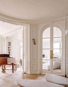 Fluffy cream covered chair with yellow cushion, floor lamp, on cover of 'Timeless Living Yearbook 2024', by Beta-Plus.