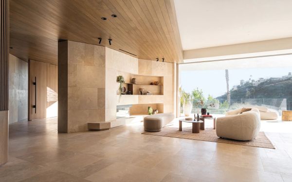 Interior with cream textured walls, with arched double doors, wooden chair and table, on cover of 'Contemporary Living Yearbook 2024', by Beta-Plus.