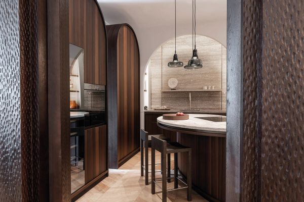 Interior with cream textured walls, with arched double doors, wooden chair and table, on cover of 'Contemporary Living Yearbook 2024', by Beta-Plus.