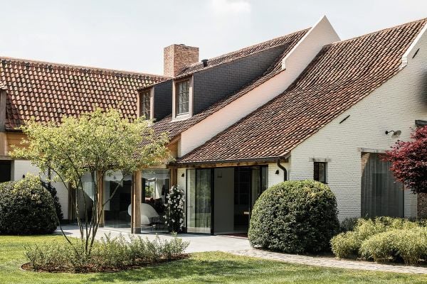 Book cover of am designs; featuring an interior living room with wood ceiling beams above a long table with chairs. Published by Beta-Plus.
