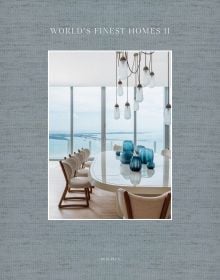 Book cover of World's Finest Homes II; featuring a modern interior living space with large dining table, and views out to a river. Published by Beta-Plus.