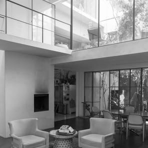 Horizontal photo of 2 figures carry board up slated platform, Exposed Architecture in black font on pale orange cover