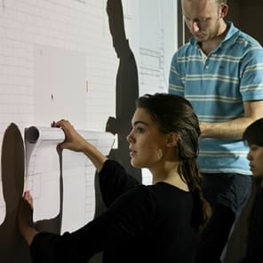 Technical drawing on brick facade in brown and beige, Crafting the Facade in stencilled font above