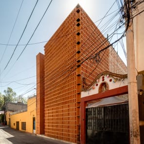 Low angled shot of centre of brick structure, panes of glass to centre, white border, BRICK 20 Outstanding International Brick Architecture in black font to top left.
