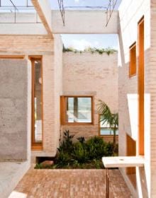 Low angled shot of centre of brick structure, panes of glass to centre, white border, BRICK 20 Outstanding International Brick Architecture in black font to top left.