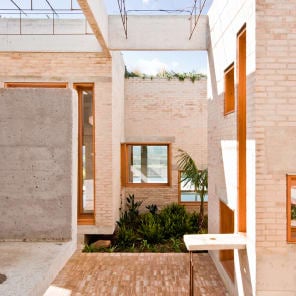 Low angled shot of centre of brick structure, panes of glass to centre, white border, BRICK 20 Outstanding International Brick Architecture in black font to top left.