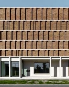 Low angled shot of centre of brick structure, panes of glass to centre, white border, BRICK 20 Outstanding International Brick Architecture in black font to top left.
