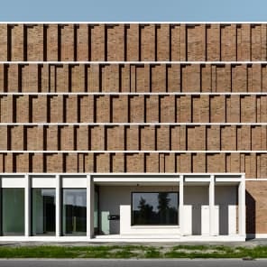 Low angled shot of centre of brick structure, panes of glass to centre, white border, BRICK 20 Outstanding International Brick Architecture in black font to top left.