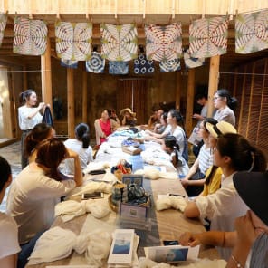 Row of wood buildings, steps leading up towards hilly landscape, The Songyang Story in black font above.