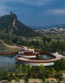 Row of wood buildings, steps leading up towards hilly landscape, The Songyang Story in black font above.
