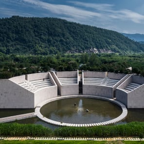 Row of wood buildings, steps leading up towards hilly landscape, The Songyang Story in black font above.