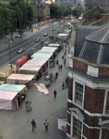 High perspective street view in London with traffic on road and Daniela Keiser London – Being in the Library in white font with text to right in white