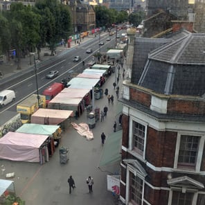 High perspective street view in London with traffic on road and Daniela Keiser London – Being in the Library in white font with text to right in white