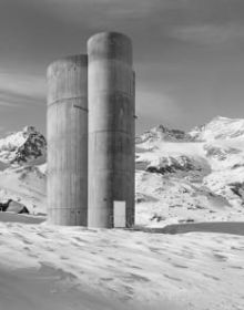 Black and white atmospheric photo of mountainous landscape with white mist and Bernina transversal in white font in cross shape
