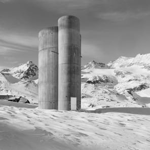 Black and white atmospheric photo of mountainous landscape with white mist and Bernina transversal in white font in cross shape