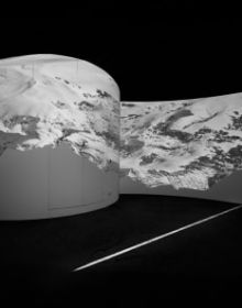 Black and white atmospheric photo of mountainous landscape with white mist and Bernina transversal in white font in cross shape