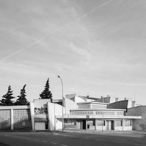 Black and white image of white high rise building complex surrounded by large trees with Hidden in Plain Sight in light orange font