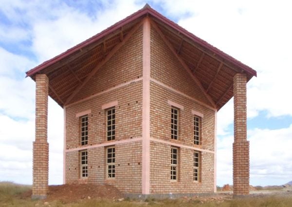 Book cover of A Home for Advan FC: Handbook for a Madagascan Building with Global Adaptability, with a brick building surrounded by grass, and seven footballers below. Published by Park Books.