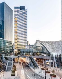 Colour photo of 32-storey high-rise Trinity tower with glass exterior shining in sunlight and Cro&Co in small white font below