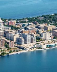 Book cover of Living Cities: Three Centuries of Park Systems, with an aerial view of brown fields, green space, and rivers. Published by Park Books.