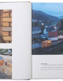 Book cover of Rural Vision: Building Dialogues Through Architecture, featuring a wood building with a person looking out onto a city, with their back to the viewer. Published by Park Books.