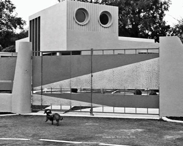 Book cover of The House of Doctor Koolhaas, with a giraffe standing next to a two-story building, and the Eifel Tower behind. Published by Park Books.