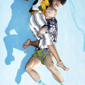 Head and shoulder green filtered shot of model, closed eyes in dress and long earrings, Wild Thing in white font below.