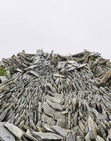 Wall of stone blocks, brick pile below, on white cover, Georg Aerni Silent Transition in beige font below