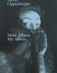 Book cover of Meret Oppenheim Mein Album My Album, featuring the artist and photographer peering through a veil of black lace. Published by Scheidegger & Spiess.