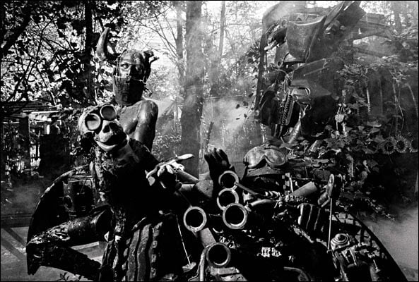 Book cover of HR Giger by Camille Vivier, with a photograph of H.R Giger pinned to wall, with a skull featuring black symbols. Published by Scheidegger & Spiess.