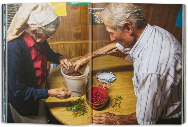 Book cover of Vrin: Home Through An Emigrant's Lens, with a person carrying two containers in snowy weather. Published by Scheidegger & Spiess.