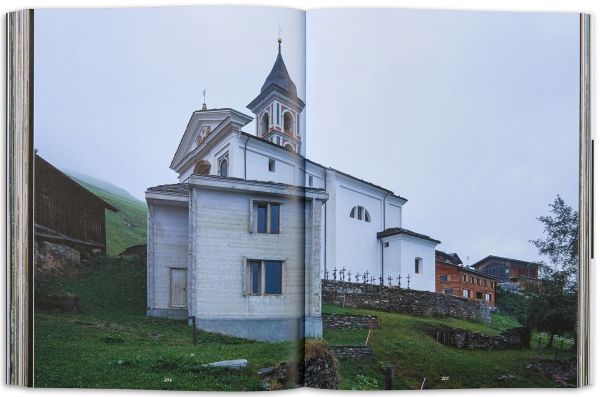 Book cover of Vrin: Home Through An Emigrant's Lens, with a person carrying two containers in snowy weather. Published by Scheidegger & Spiess.