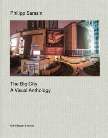Book cover of The Big City: A Visual Anthology; featuring a nighttime urban scene with illuminated billboards and modern architecture. Published by Scheidegger & Spiess.
