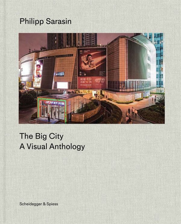 Book cover of The Big City: A Visual Anthology; featuring a nighttime urban scene with illuminated billboards and modern architecture. Published by Scheidegger & Spiess.