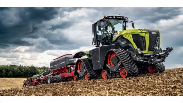 Aerial photograph of a combine harvester driving through green circuit board graphic, on cover of 'Sowing Ideas Harvesting the Future', by Delius Klasing.
