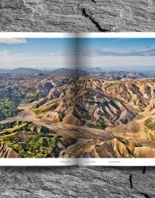 Mountainous landscape with green terrain with winding roads, on cover of 'Mountain Roads, Aerial Photography. Traumstraßen der Welt / Dreamroads of the world', by Delius Klasing Verlag GmbH.