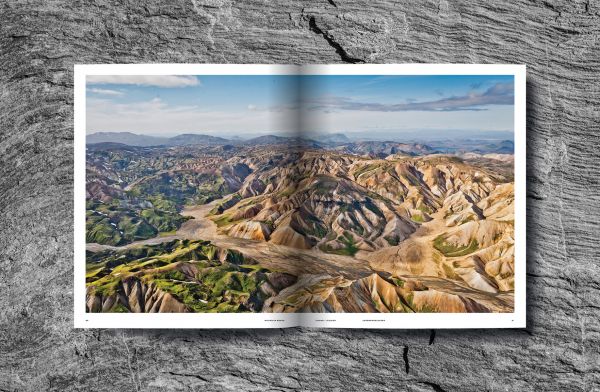 Mountainous landscape with green terrain with winding roads, on cover of 'Mountain Roads, Aerial Photography. Traumstraßen der Welt / Dreamroads of the world', by Delius Klasing Verlag GmbH.