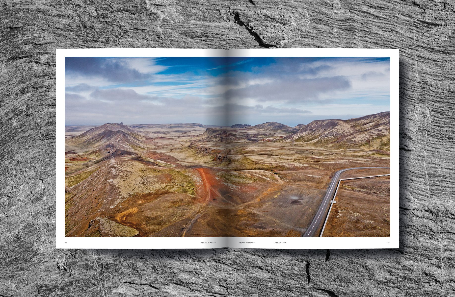 Mountainous landscape with green terrain with winding roads, on cover of 'Mountain Roads, Aerial Photography. Traumstraßen der Welt / Dreamroads of the world', by Delius Klasing Verlag GmbH.