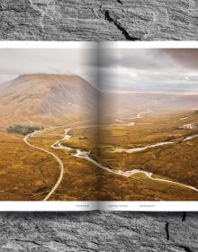 Mountainous landscape with green terrain with winding roads, on cover of 'Mountain Roads, Aerial Photography. Traumstraßen der Welt / Dreamroads of the world', by Delius Klasing Verlag GmbH.