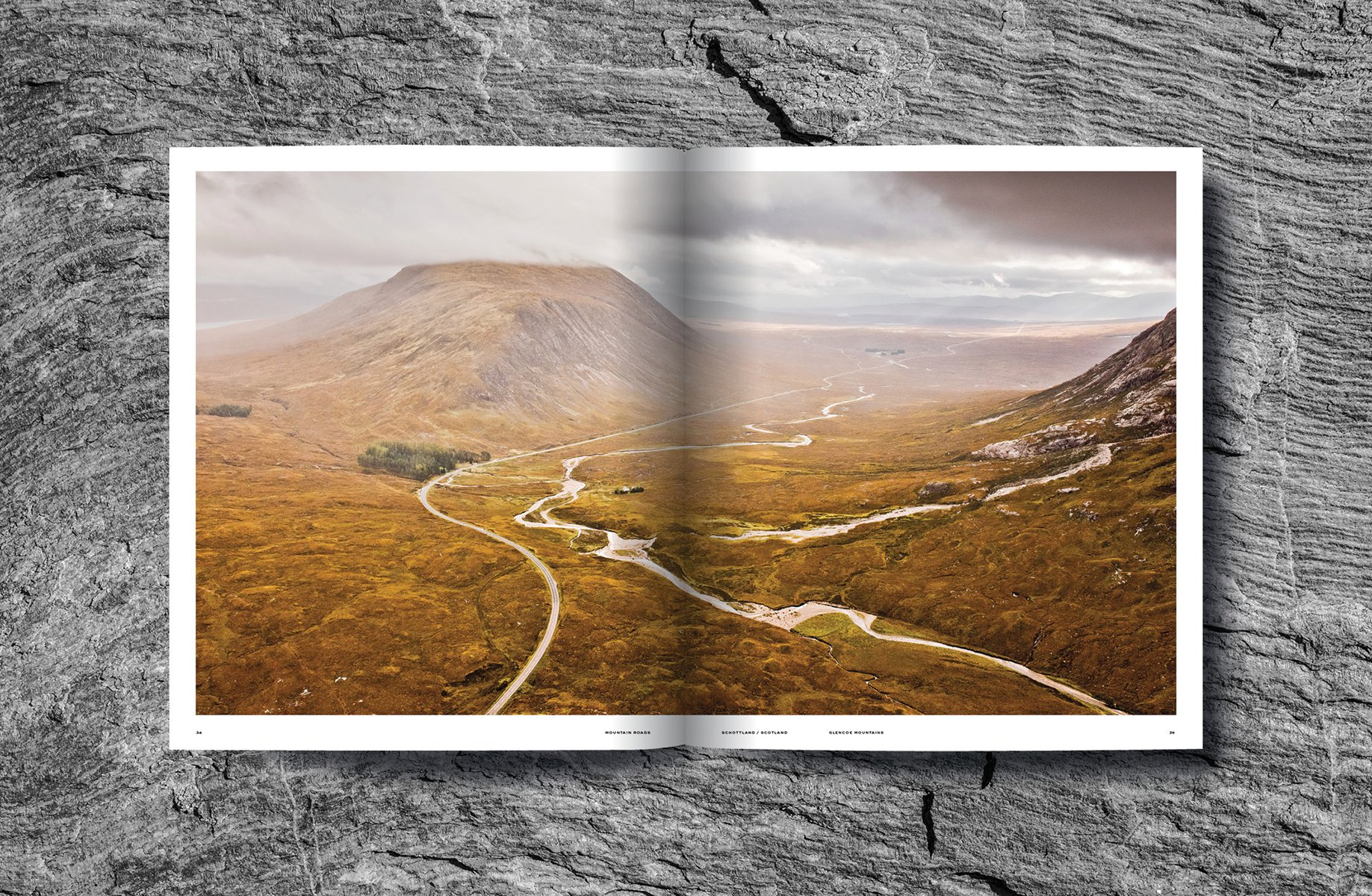 Mountainous landscape with green terrain with winding roads, on cover of 'Mountain Roads, Aerial Photography. Traumstraßen der Welt / Dreamroads of the world', by Delius Klasing Verlag GmbH.