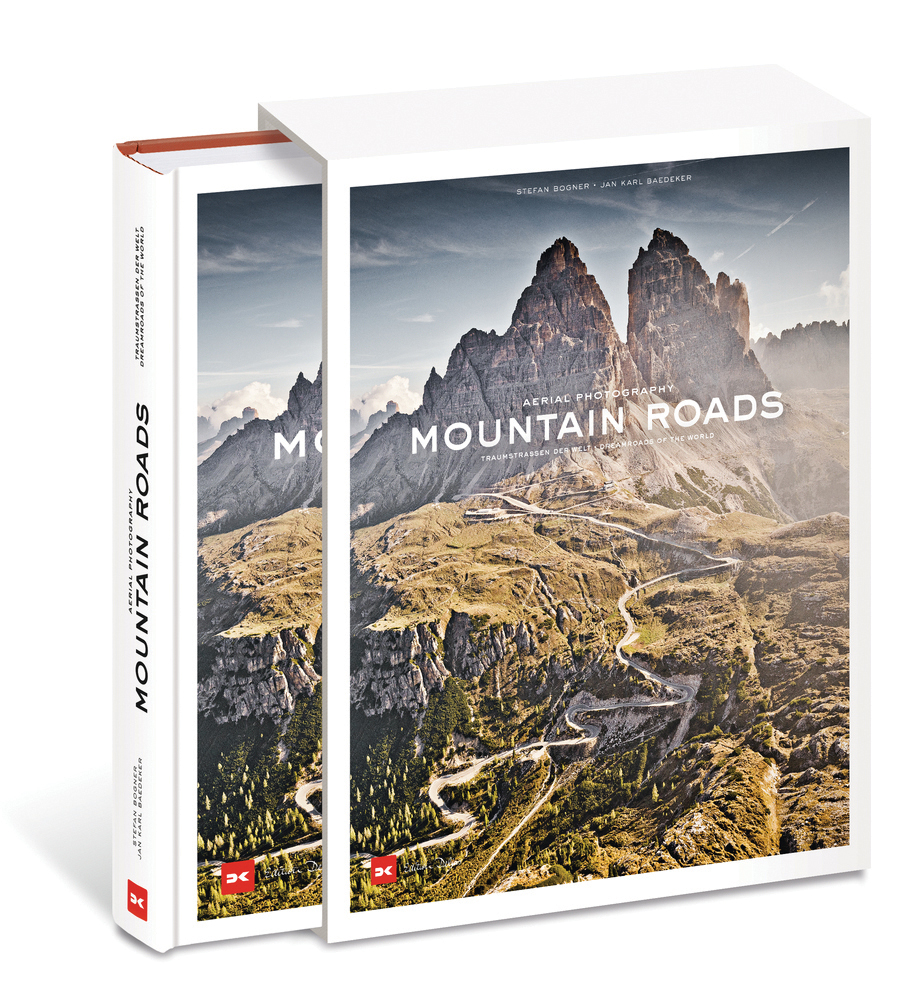 Mountainous landscape with green terrain with winding roads, on cover of 'Mountain Roads, Aerial Photography. Traumstraßen der Welt / Dreamroads of the world', by Delius Klasing Verlag GmbH.