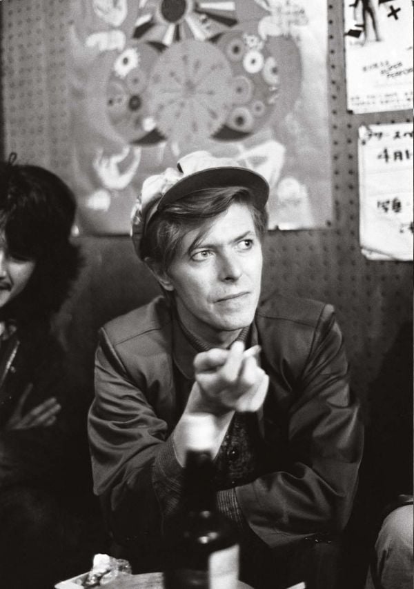 Polaroid shots of David Bowie in different poses, on black cover of 'David Bowie by Sukita', by Delius Klasing.