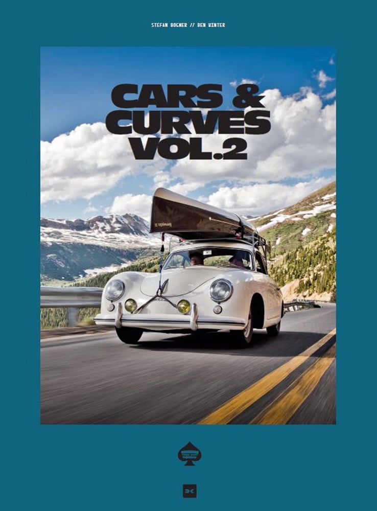 Cream Porsche 356 with small boat on roof rack travelling on road with mountains behind and Cars & Curves Vol.2 in black font above