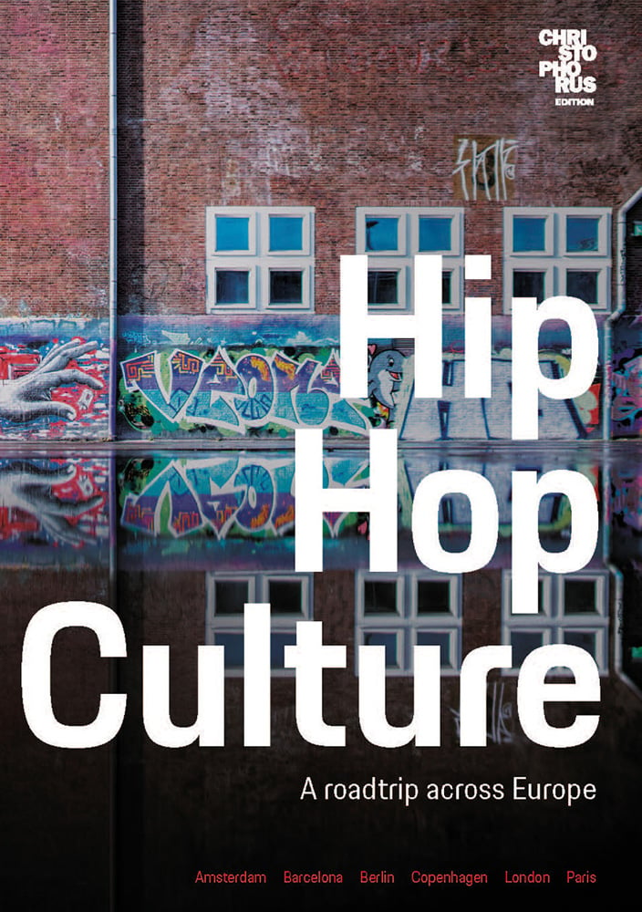 Graffitied brick wall with windows and Hip Hop Culture in white font