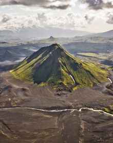 Mountainous landscape with lake and winding road in distance, on cover of 'Curves: Iceland, Volume 16', by Delius Klasing Verlag GmbH.