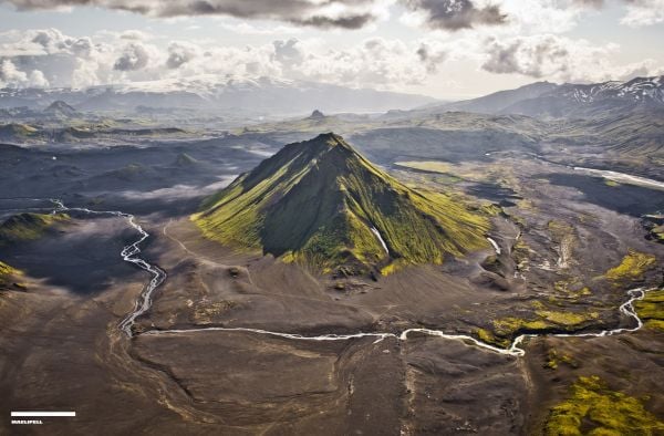 Mountainous landscape with lake and winding road in distance, on cover of 'Curves: Iceland, Volume 16', by Delius Klasing Verlag GmbH.